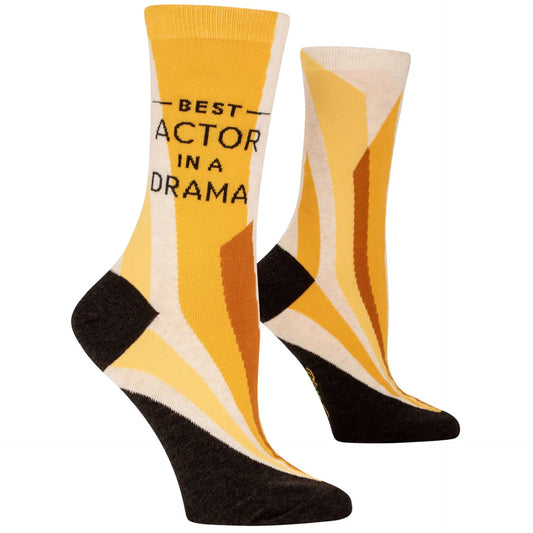 A pair of socks with a geometric pattern in yellow, black, and white colors, and the text 'BEST ACTOR IN A DRAMA' printed on the side.