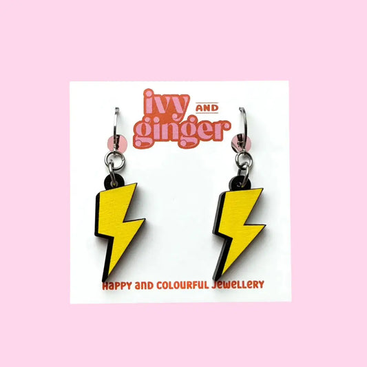 Wooden dangle lightening shaped yellow earrings displayed on a white backing card