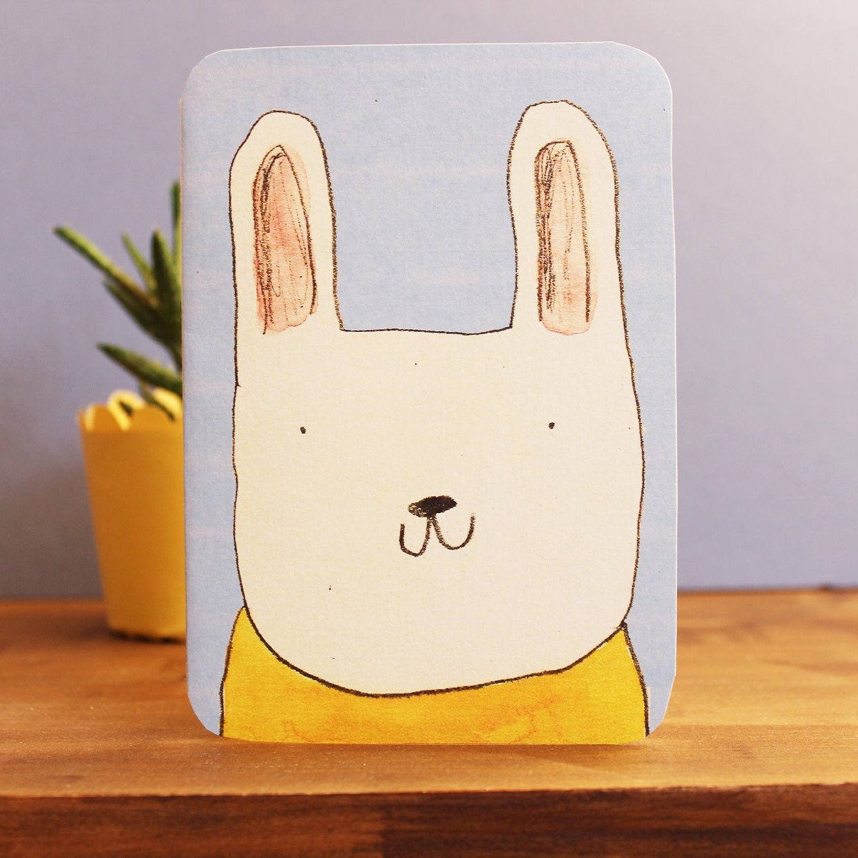 Card with a rabbit illustration on a wooden surface