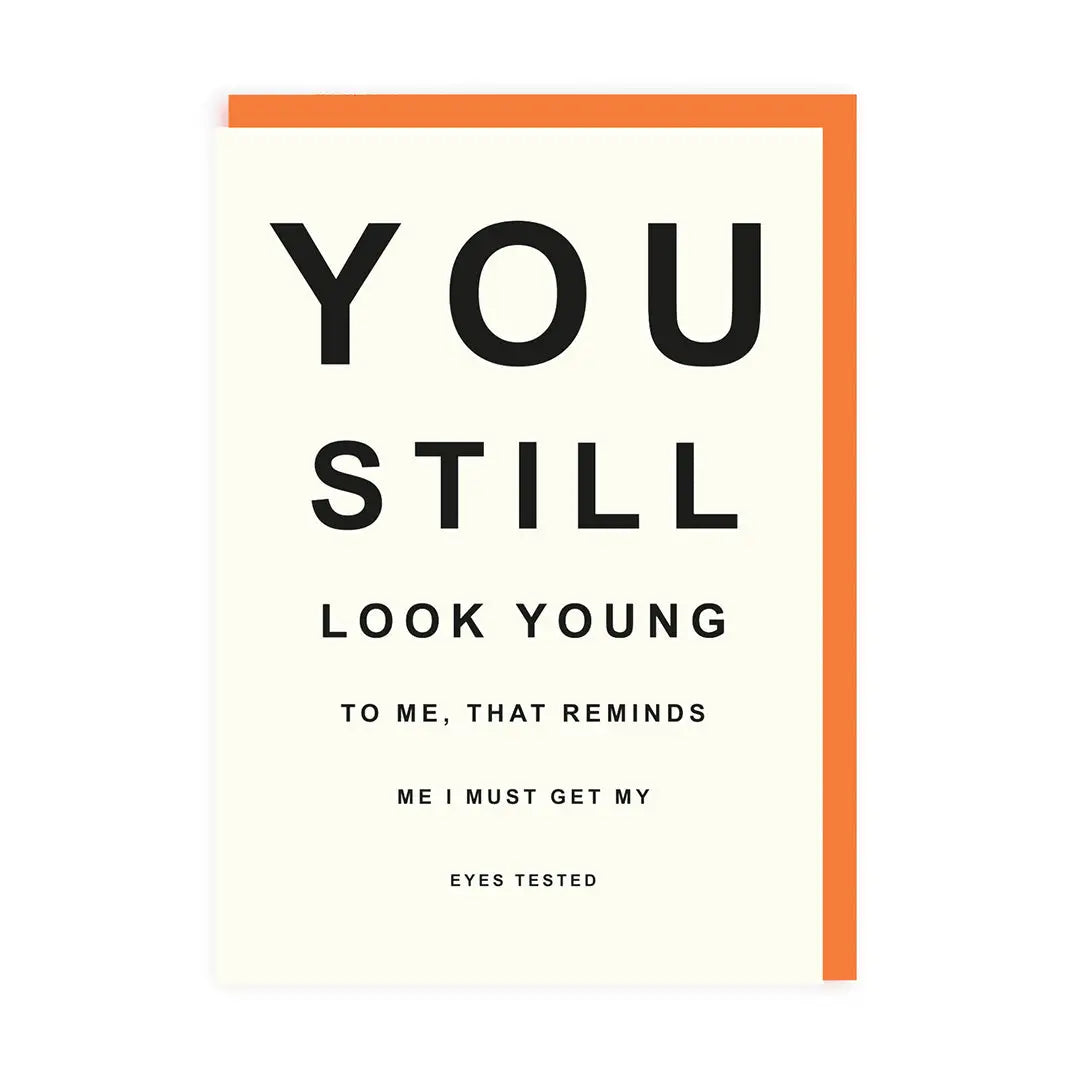 Greeting card with the text 'YOU STILL LOOK YOUNG TO ME, THAT REMINDS ME I MUST GET MY EYES TESTED' on the front, with a orange envelope.