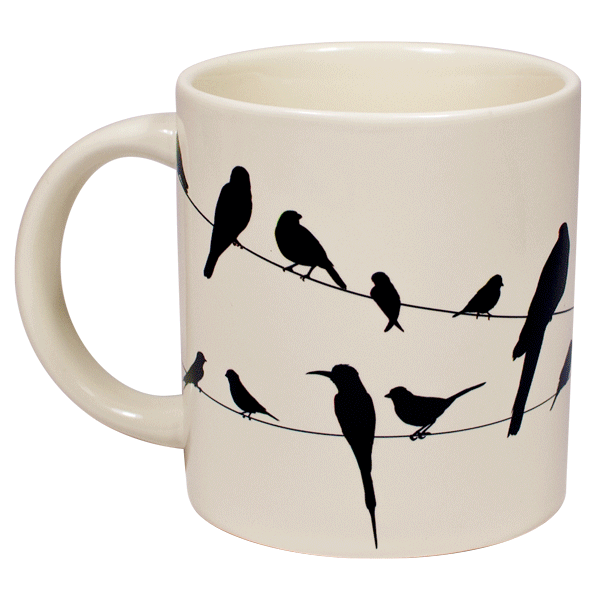 A cream mug with silhouettes of birds on a wire all over, when hot water is poured in they become colourful