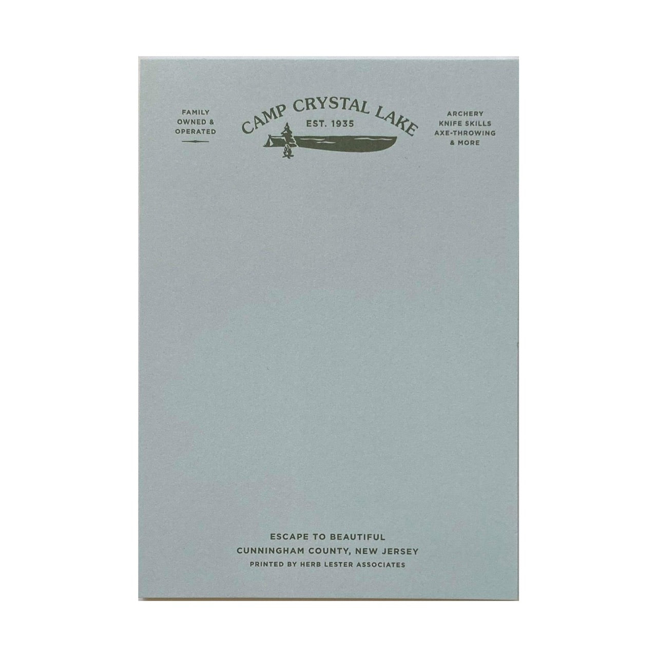 A light blue notepad with 'Camp Crystal Lake' written on the top.