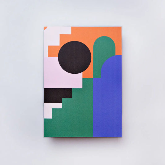 A rectangular notebook with geometric shapes in black, blue, green, orange and pink colours 