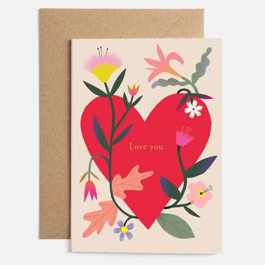 A colourful card with a large red heart surrounded by flowers + leaves, with the words Love you written inside the heart