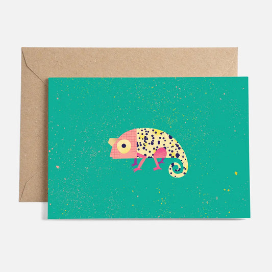 A greeting card with a colourful illustration of a stylized chameleon on a green background, placed on a brown envelope.