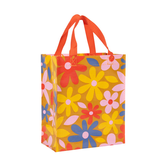 A small orange lunch bag with red handles and yellow, red, blue and pink flowers all over.