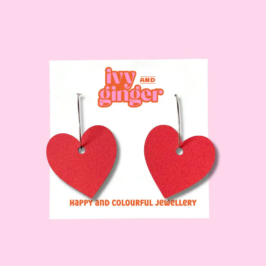 A pair of red heart-shaped wooden earrings on a white background with the brand name 'Ivy and Ginger' displayed above.