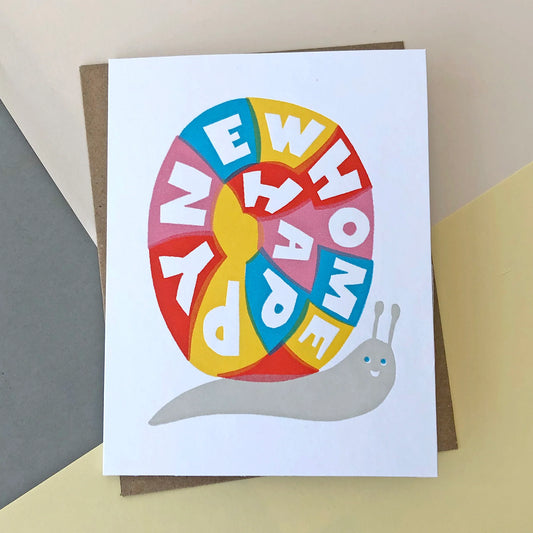 A new home card with a colourful snail on the front. It has text on the snails shell that reads ' Happy new home '