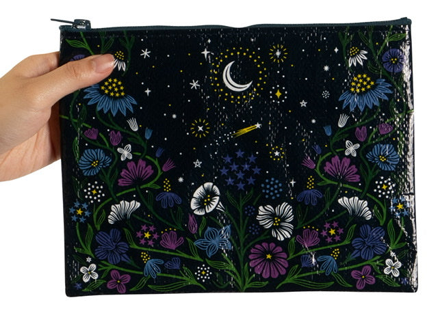 Someone holding a Blue Q zipper pouch with flowers around and white and yellow stars and a moon on the top