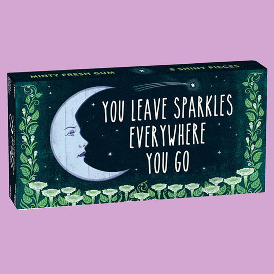 A Box of Blue Q gum with a moon and green flowers on the front. The text reads: You leave sparkles everywhere you go