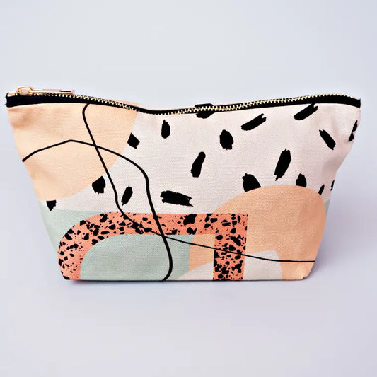 A cosmetic bag with light pink, light green and light orange funky shapes and lines on 