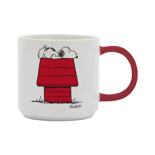 A white mug with a red handle.  The image on the mug shows Snoopy asleep on top of a house