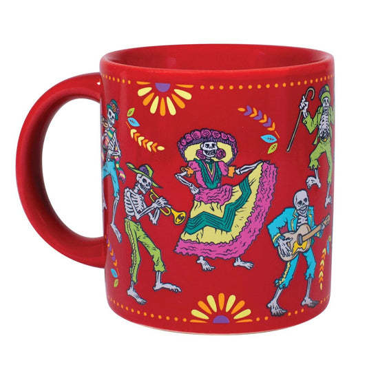 A red mug with colourful dancing skeletons all over dressed for day of the dead. The skeleton's are only visible when the mug is filled with a hot liquid.  