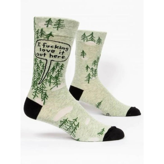 Blue Q socks with green trees. There is a speech bubble coming from behind the trees that reads: 'I fucking love it out here'