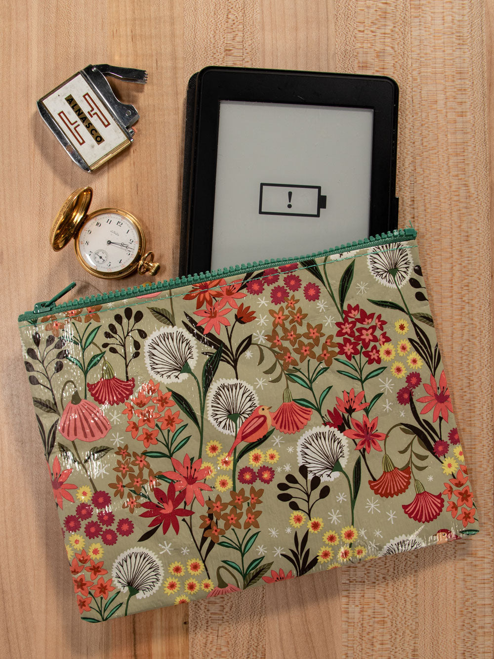 A beige Blue Q Zipper pouch with pink, red, orange and green flowers all over and white daffodils.