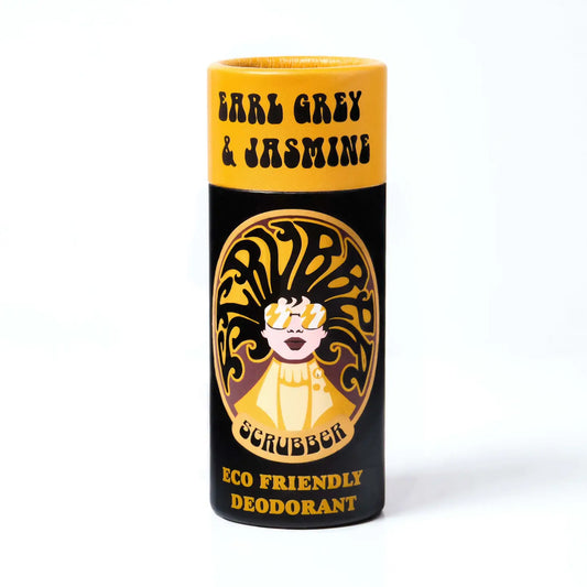 A black and yellow cardboard tube containing eco friendly deodorant. in the middle is an image of a woman wearing sunglasses and her hair forms the word 'scrubber' The text on the tube reads: 'Earl grey & jasmine - scrubber - eco friendly deodorant'