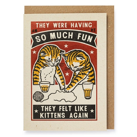 A white card with 2 kittens on the front that are palying with a ball of yarn. They are orange and black striped cats and also have drinks infront of them on the table. The background of the card is red and has text on that says: 'They were having so much fun they felt like kittens again'