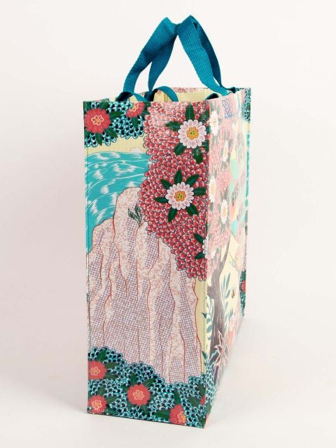 The side of the Blue Q 'Trees are cool' shopper. There is a mountain with water and some flowers.