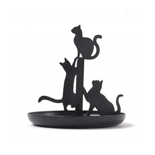 The silhouettes of 3 black cats jumping up a pole with a black dish underneath used for storing jewellery