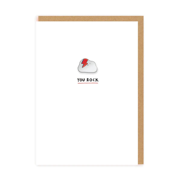 A white card with a pin badge in the middle of a rock with a Bowie 'flash' on. The text on the card reads: You rock