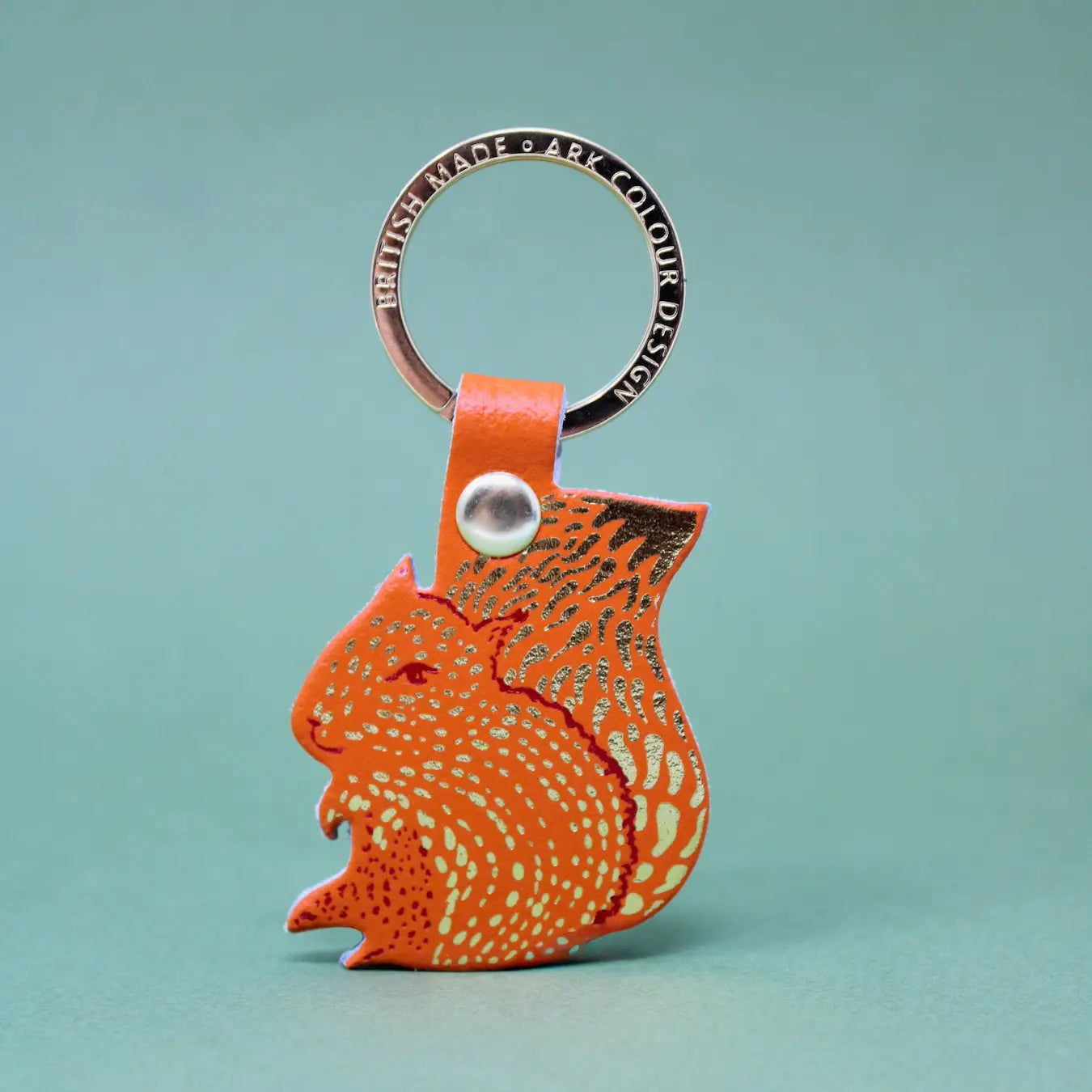 Orange squirrel-shaped keychain on a light blue background