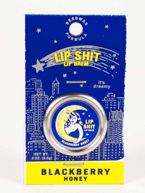 Blue Q lip shit tin encased in cardboard packaging. The text reads: 'Lip shit lip balm - Blackberry Honey'