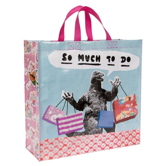 A Blue Q shopper with Godzilla on the front with shopping bags, The text reads: So much to do
