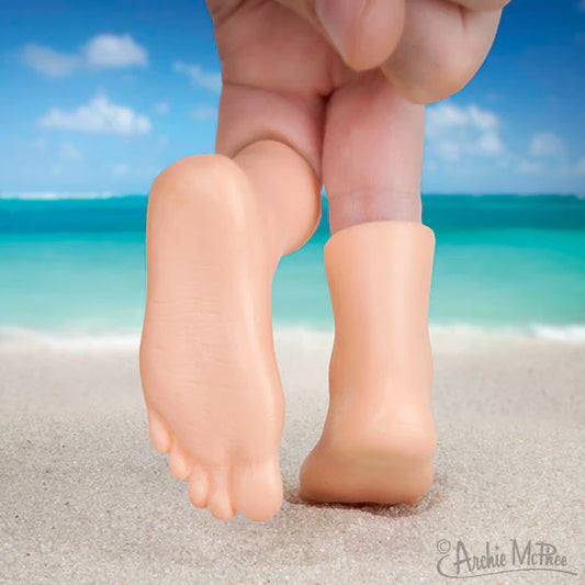 A pair of Archie McPhee finger feet on someone hand being used to walk in the sand on a beach 