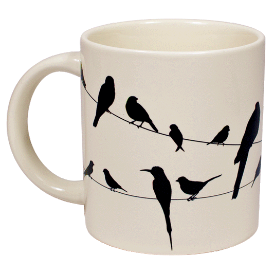 A cream mug with silhouettes of birds on a wire all over, when hot water is poured in they become colourful