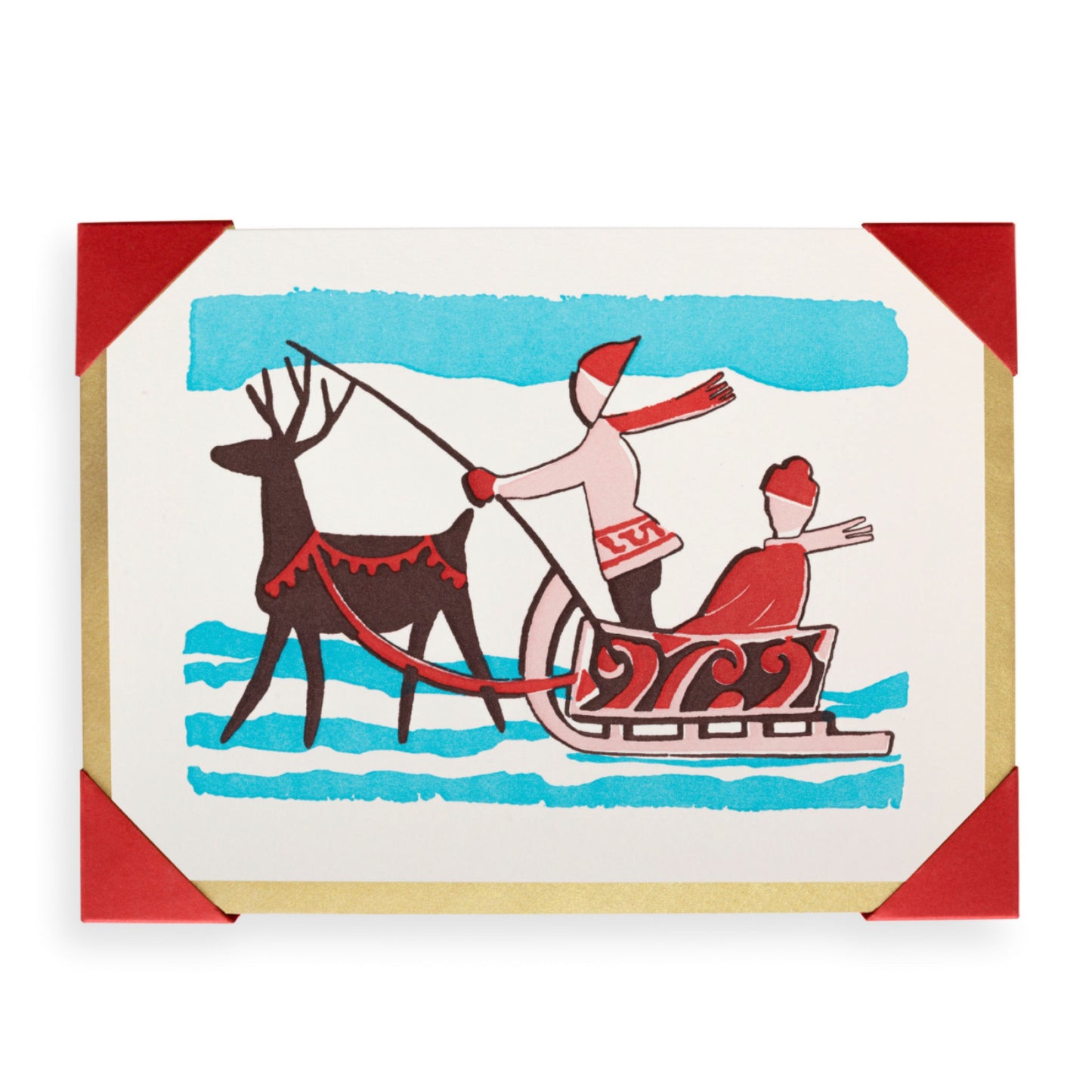 A red and blue archivist letterpress card with 2 people riding a sleigh that’s being pulled along by a reindeer.