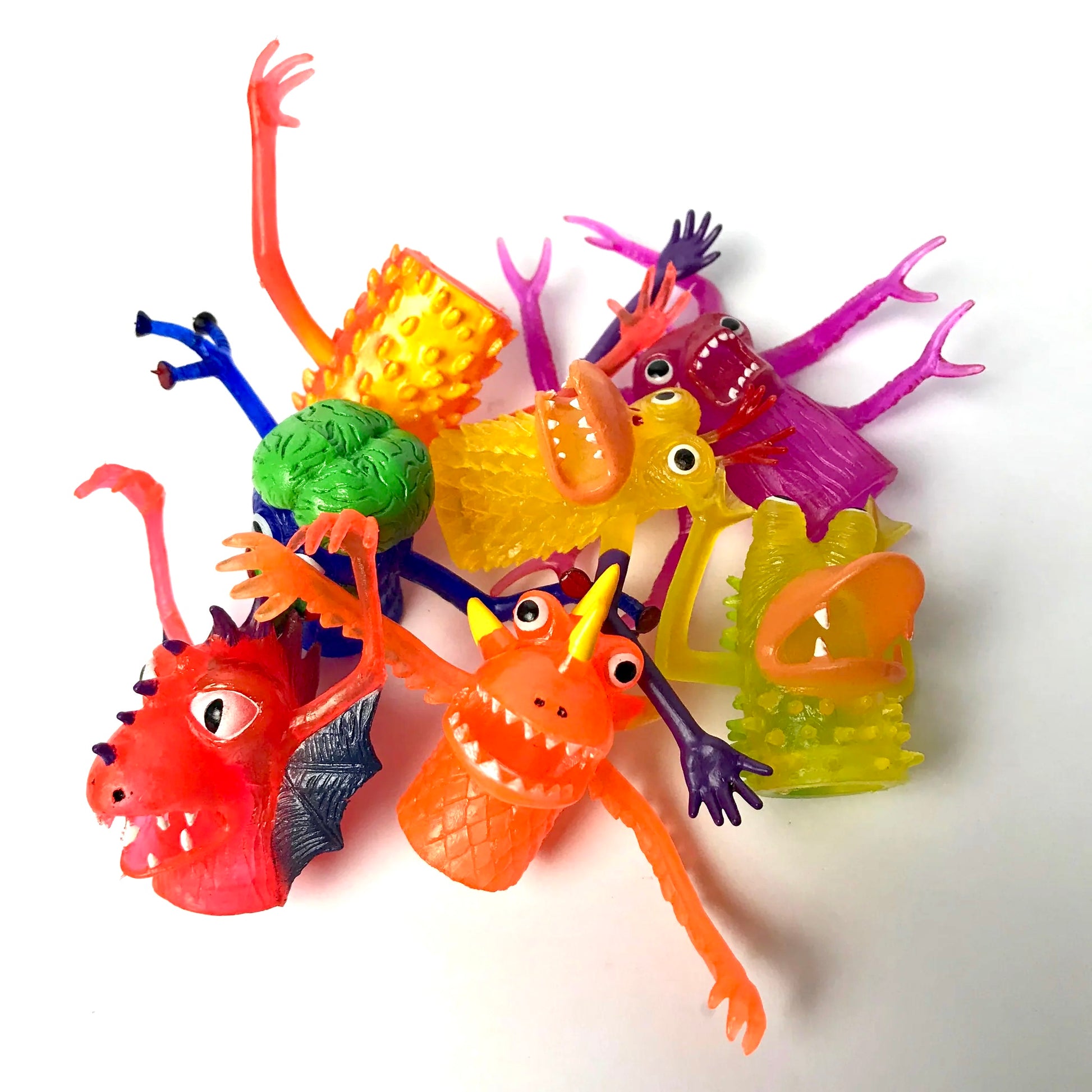 A group of seven finger monster puppets of different shapes and sizes are sitting together on a white background.