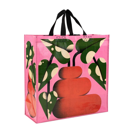 A pink tote bag with an image of a green and white plant inside of an orange bubble vase. 