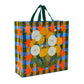 A green, blue and orange checked tote bag with green handles. On the bag is an image of some yellow, white and green dandelions.