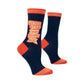 A pair of blue & orange socks with the phrase “TEACHER SOCKS 'CAUSE TEACHERS ROCK!” written in white and orange on the ankle