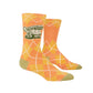 A pair of orange socks with a green and white argyle pattern and a turtle on the side. Text reads: Crotchety old fuck