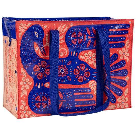 A red, blue and pink tote bag with a blue bird printed on the front. all around the bird are floral prints and patterns.