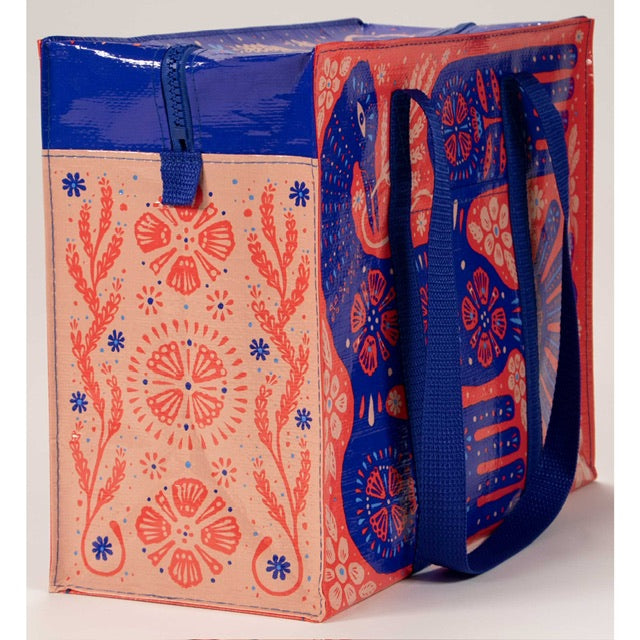 A red, blue and pink tote bag with a blue bird printed on the front. all around the bird are floral prints and patterns.