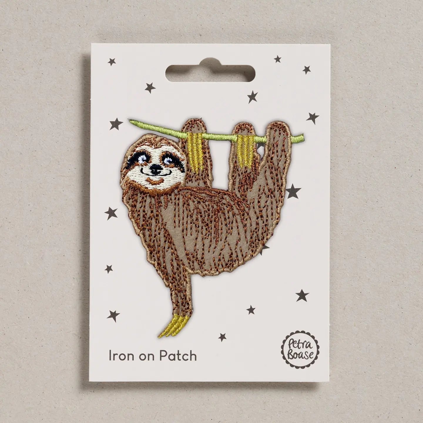 Iron on patch of a sloth on a white card with 'Petra Boase' branding.