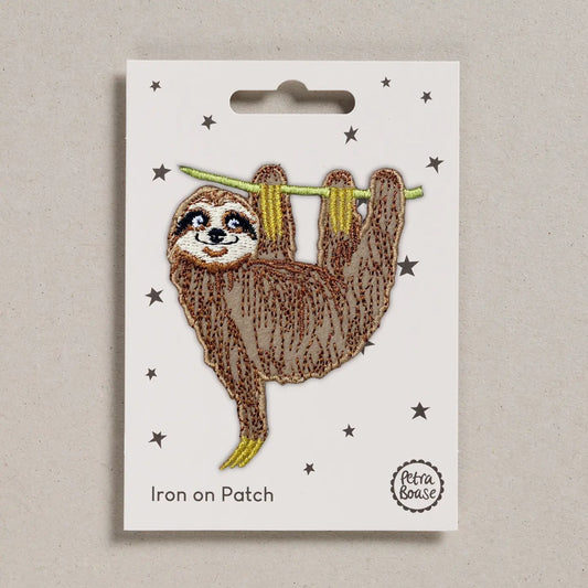 Iron on patch of a sloth on a white card with 'Petra Boase' branding.