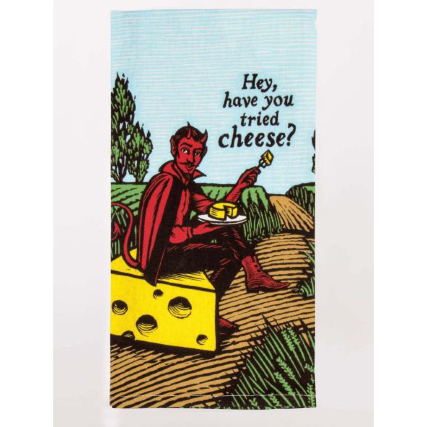 A Blue Q tea towel with the devil sat on a block of cheese in a field. The text reads: 'Hey, have you tried cheese?'