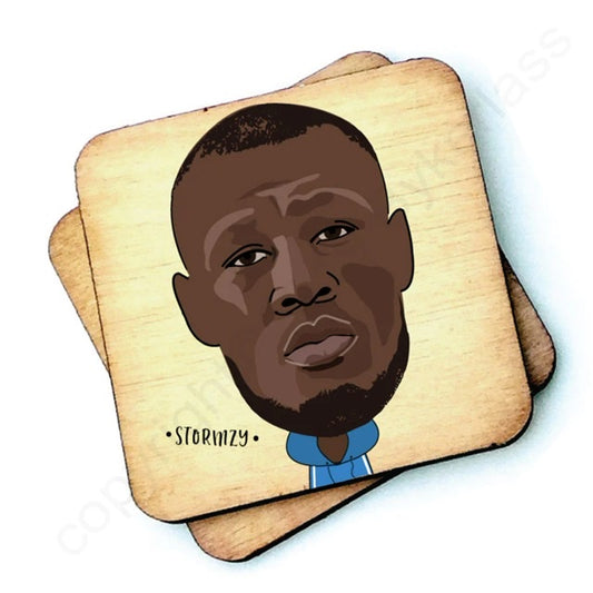 Image shows a wooden drinks coaster with a cartoon graphic of Stormzy on the front