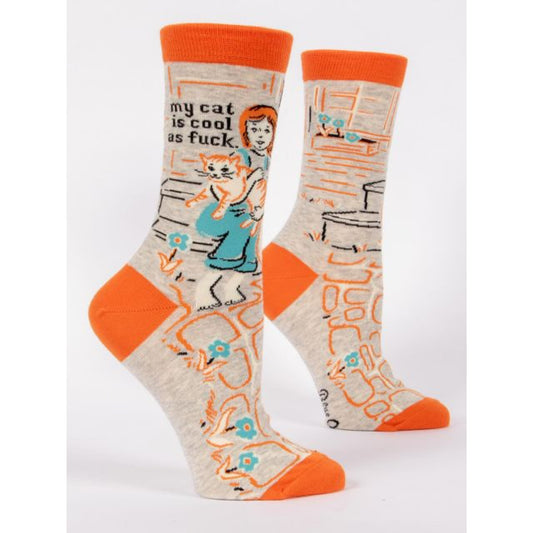 Grey and Orange Blue Q socks with a girl holding her cat in the garden. The text reads ‘my cat is cool as fuck’