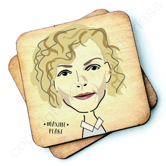 Image shows a wooden drinks coaster with a cartoon graphic of Maxine Peake on the front