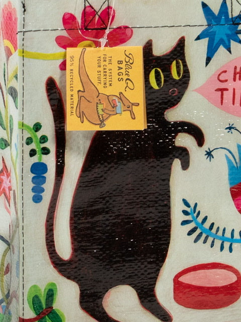A white Blue Q lunch bag with a drawing of a black cat with pink blue yellow and green around. 