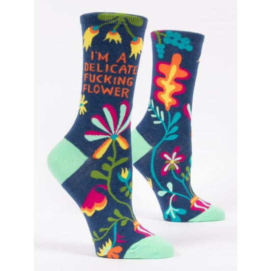 Blue Q women's socks with colourful flowers all over and a blue background. The text reads I'm a delicate fucking flower