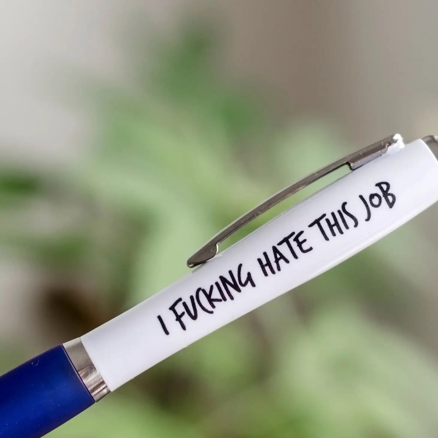 A white and blue coloured pen that reads: I fucking hate my job