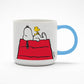 A white mug with a blue handle. There is a graphic of Snoopy laying on top of a shed with Woodstock sat on top of his belly.