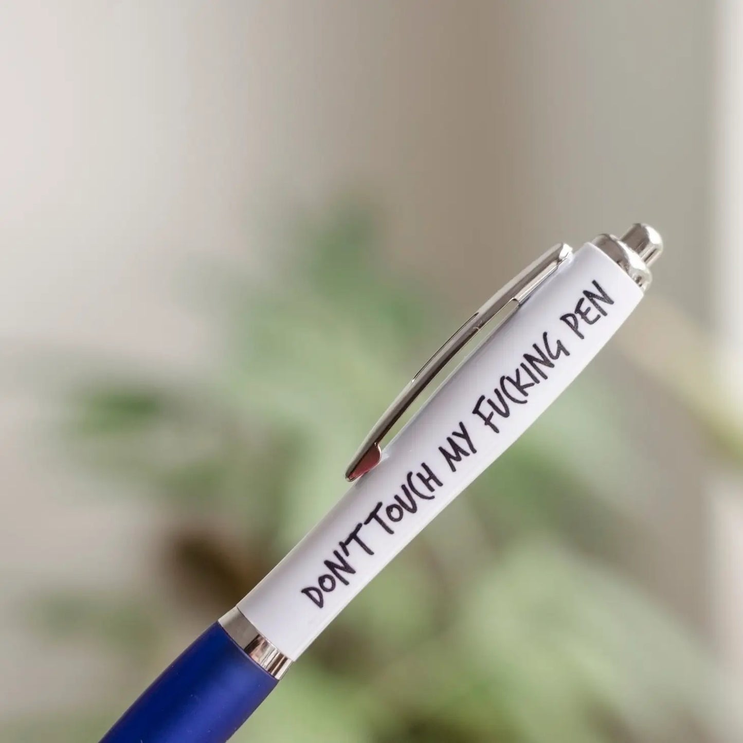 A white and blue coloured pen that reads: Don't touch my fucking pen