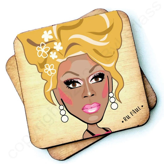 Image shows a wooden drinks coaster with a cartoon graphic of Ru Paul on the front