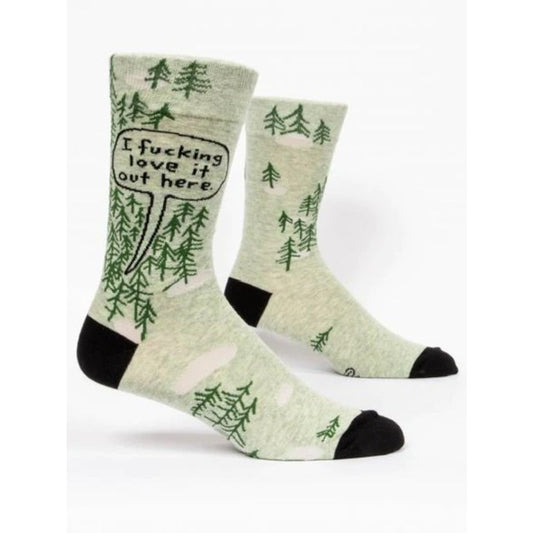 Blue Q socks with green trees. There is a speech bubble coming from behind the trees that reads: 'I fucking love it out here' 